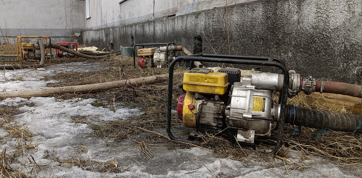 Откачка мотопомпами талой воды из подвала дома в Корсакове